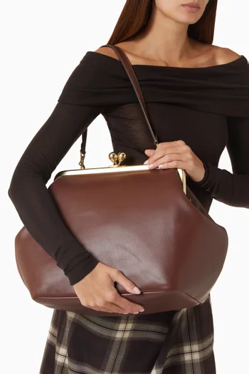 حقيبة كبيرة بقفل متقاطع وإطار جلد