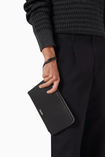 حقيبة صغيرة بحمالة معصم وحلية شعار الماركة جلد