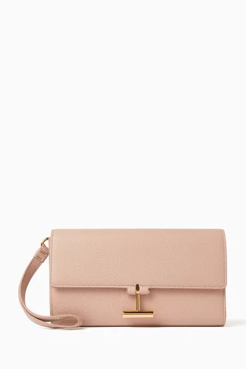 حقيبة صغيرة بحمالة معصم وغطاء قلاب بشعار حرف T جلد