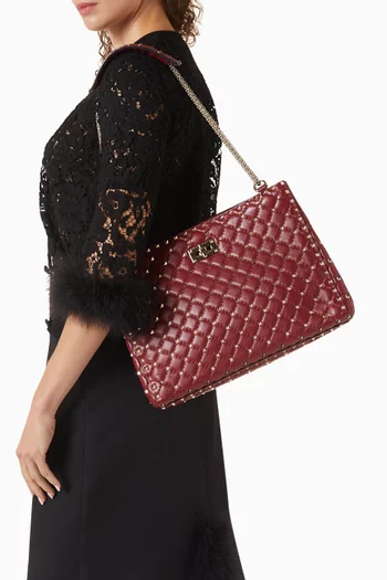 حقيبة يد مبطنة بحلي هرمية مدببة وسلسلة جلد